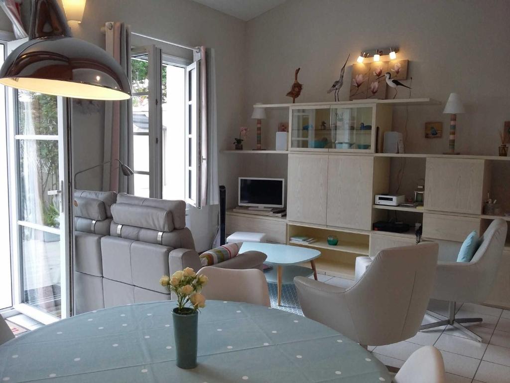 a living room with a table and chairs and a couch at Appartement Saint-Martin-de-Ré, 3 pièces, 4 personnes - FR-1-544-10 in Saint-Martin-de-Ré