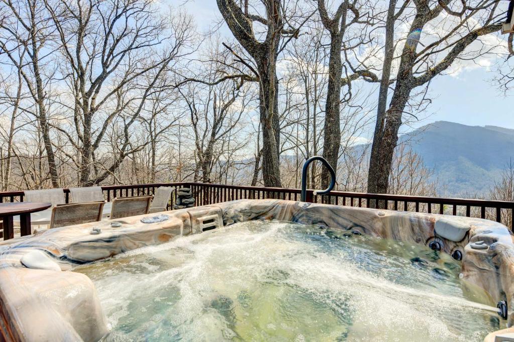 a jacuzzi tub in a park with trees at Stunning Maggie Valley Getaway with Decks, Fire Pit! in Maggie Valley