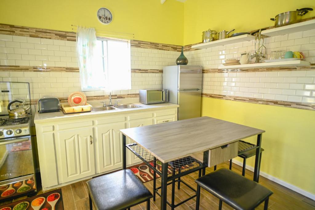 uma pequena cozinha com uma mesa e um lavatório em La Vue em Anse La Raye