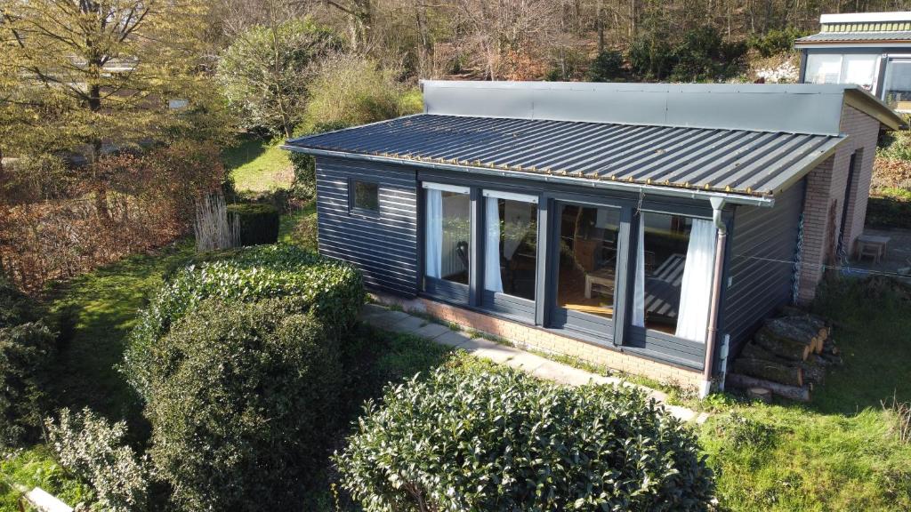 een tiny house met een tinnen dak en ramen bij Ferienhaus Nr. 12 am Südhang der Bentheimer Berge nah an der Natur in Bad Bentheim