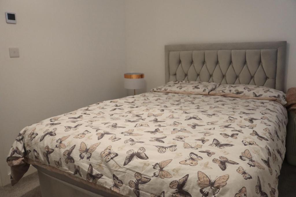 a bed with a bedspread with butterflies on it at Double room in Petersborough in Peterborough