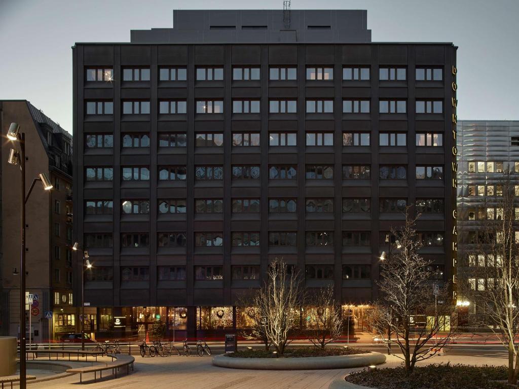 un grand bâtiment noir avec des arbres devant lui dans l'établissement Downtown Camper by Scandic, à Stockholm