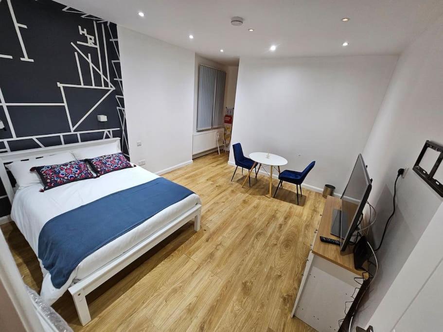 1 dormitorio con 1 cama, mesa y sillas en cosy apartment Alexandra palace Haringey, London en Londres
