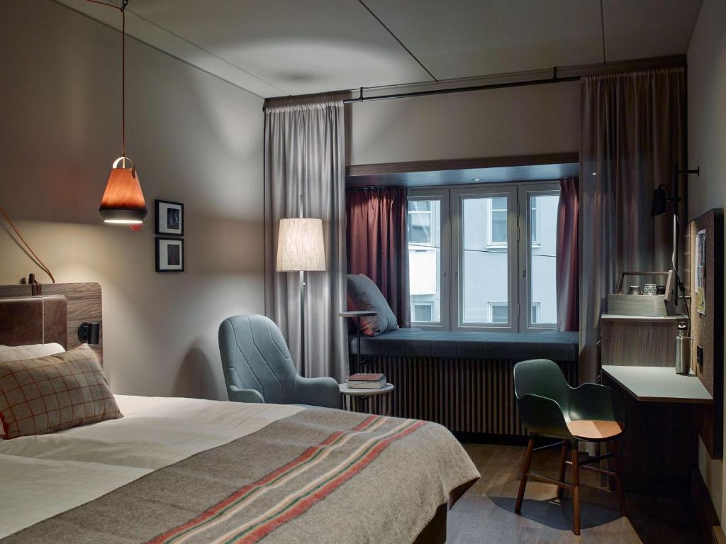 a hotel room with a bed and a desk and chairs at Downtown Camper by Scandic in Stockholm