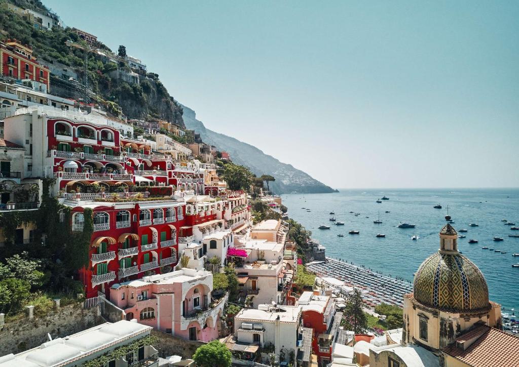 a group of buildings on a hill next to the ocean at Le Sirenuse in Positano