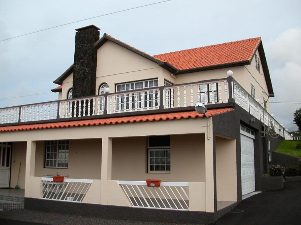 une maison avec un balcon au-dessus dans l'établissement Moradia Familiar NovaVista - T3, à Madalena