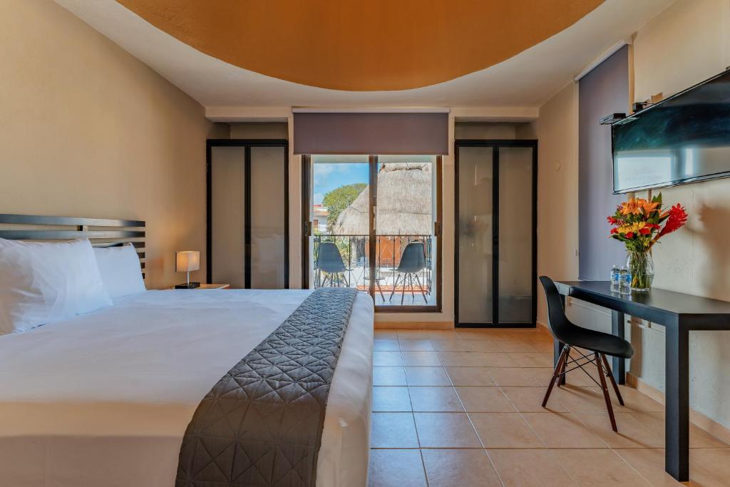 Habitación de hotel con cama, escritorio y mesa. en Hotel Brisas 5a AV, Playa del Carmen en Playa del Carmen