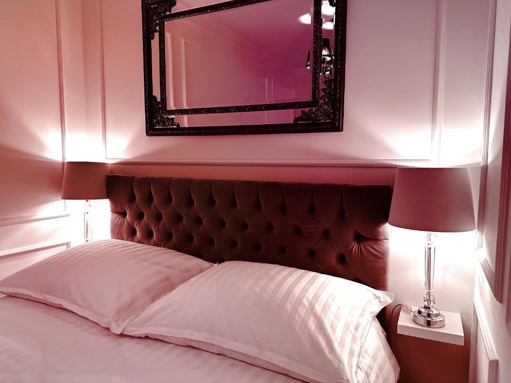 1 dormitorio con espejo sobre una cama con sábanas blancas en Hanza Tower Apartament Times Square en Szczecin