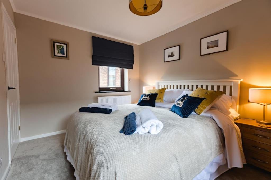 a bedroom with a large white bed with blue pillows at Hullidays》Marina Town House in Hull