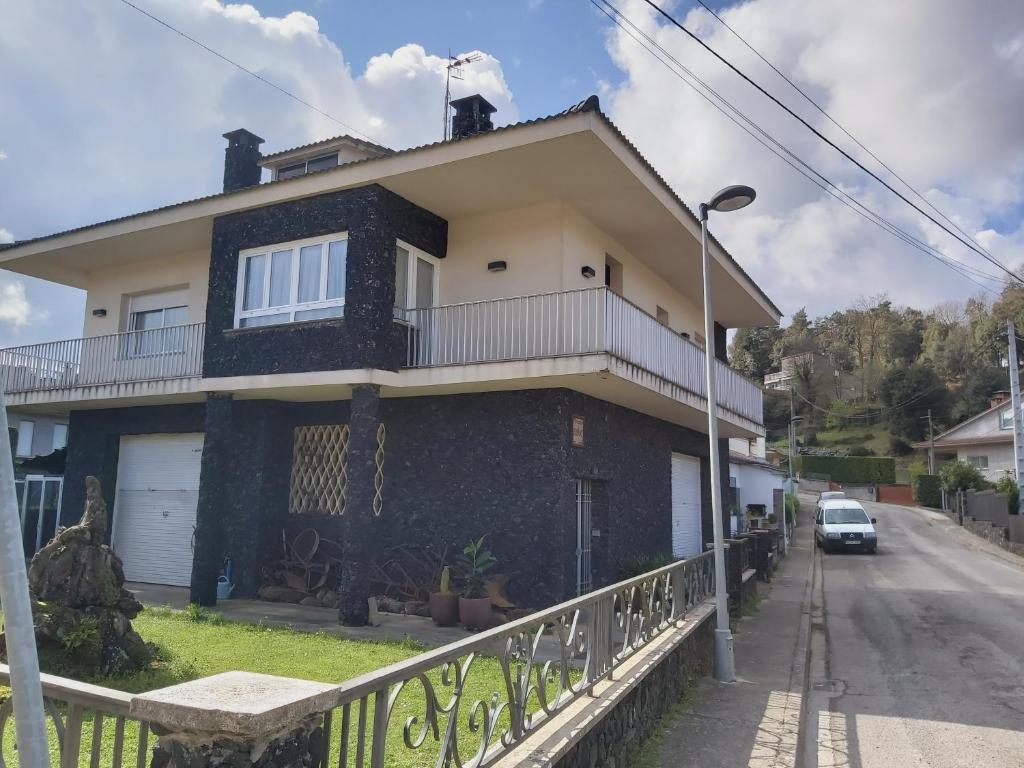 una casa negra con una valla delante en Circ 42, en Santa Pau