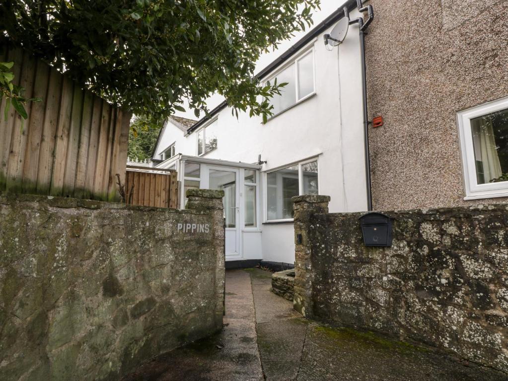 a house with a stone wall and a fence at Pippins in Bream