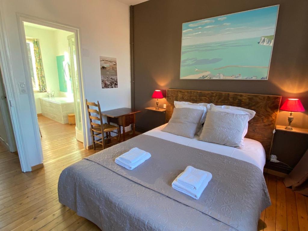 1 dormitorio con 1 cama grande y 2 toallas. en La Chambre Claire, en Ponts-et-Marais