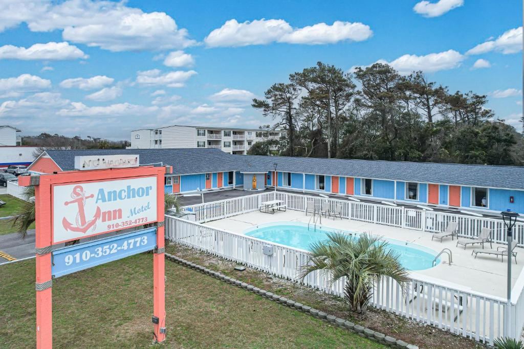 un panneau en face d'un bâtiment avec piscine dans l'établissement Anchor Inn Motel, à Île au chêne