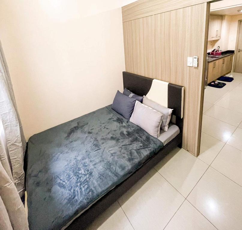 uma pequena cama num quarto com almofadas em Shore Residences Facing Pool em Manila