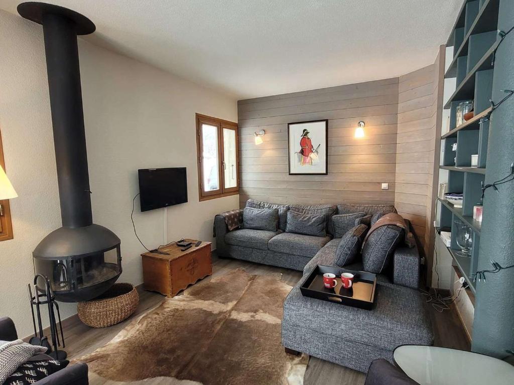un salon avec un canapé et une cheminée dans l'établissement Chalet lumineux 3* proche lac et pistes, calme, 80m VTT/ski, 2 parkings, WiFi, équipé pour 10 pers. - FR-1-598-87, aux Gets