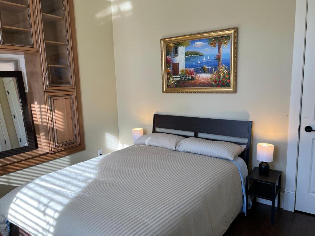 a bedroom with a bed and a painting on the wall at Mike's Luxury House in Vancouver