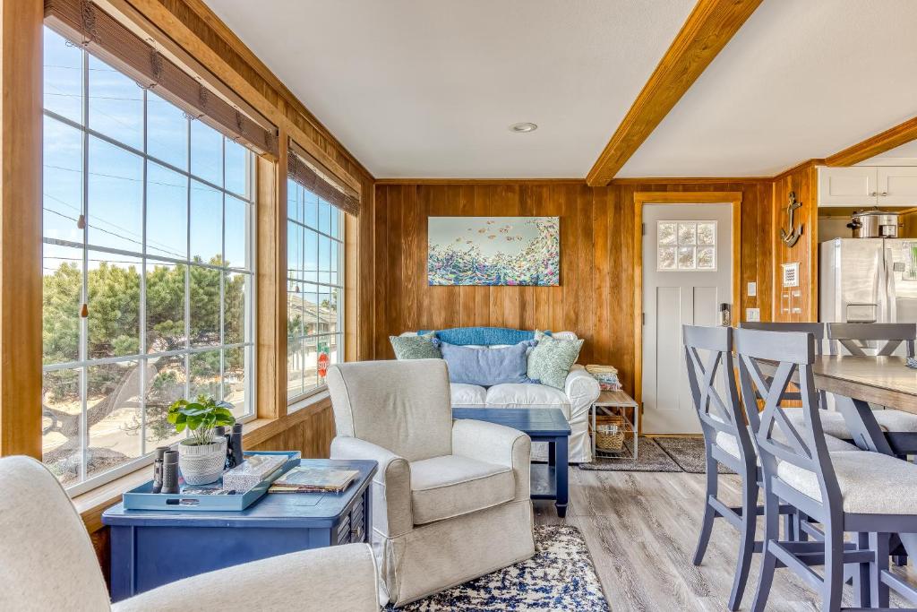 a living room with wood paneling and a table and chairs at A Slice Above in Lincoln City