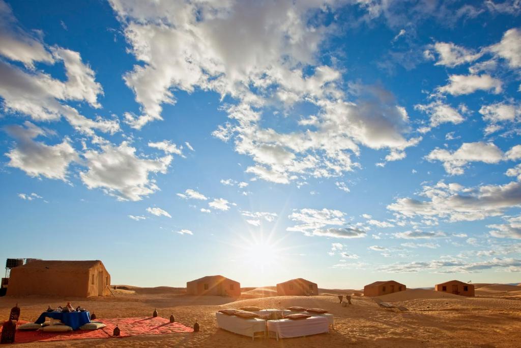 - une vue sur le désert avec le soleil dans le ciel dans l'établissement Bivouac La Dune Blanche, à M'Hamid El Ghizlane