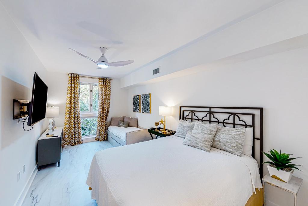 a white bedroom with a bed and a tv at Baytowne Wharf - Market Street Inn #336 in Destin