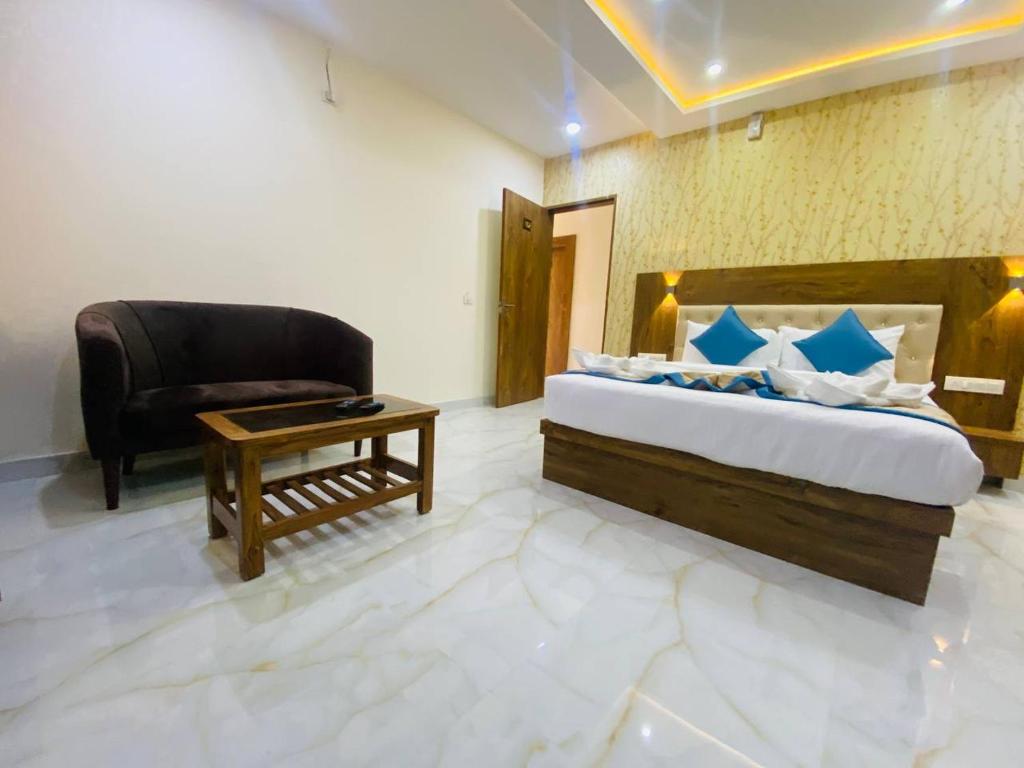 um quarto com uma cama, uma cadeira e uma mesa em Spectra Hotel Bangalore Airport em Bangalore