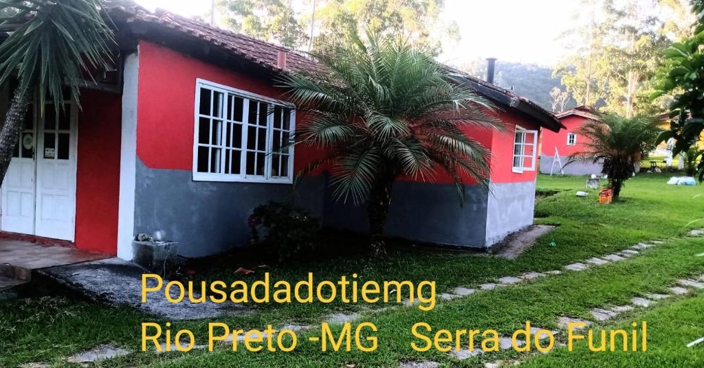 a house with a red and blue house at Pousada do Tie - Rio Preto MG in São José do Rio Preto