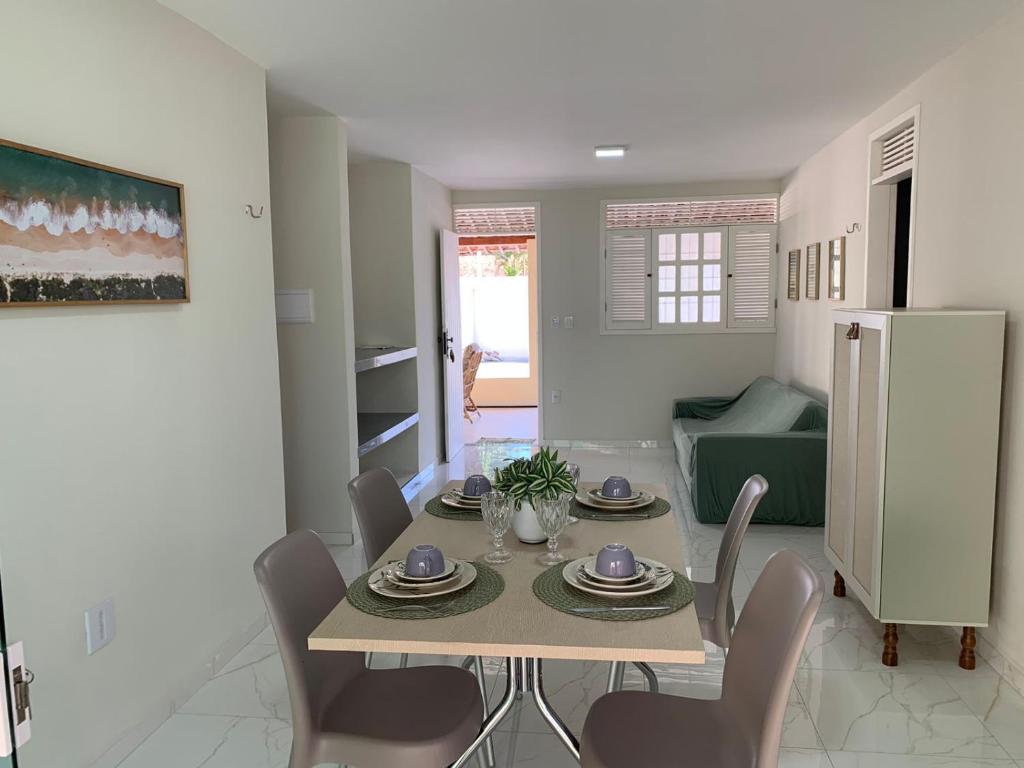 uma cozinha e sala de jantar com mesa e cadeiras em Casa na Praia de Ponta Negra em Natal