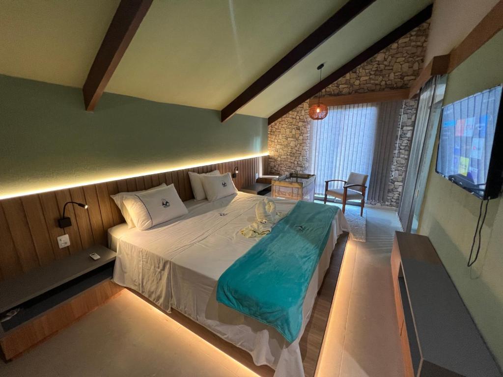 ein Schlafzimmer mit einem großen Bett und einem TV in der Unterkunft Cidade Jardim Apart in Guaramiranga