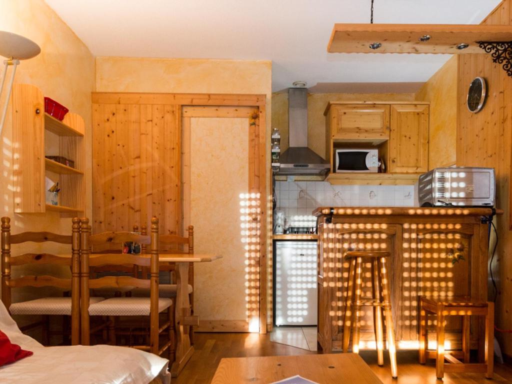 a kitchen with wooden cabinets and a dining room at Studio Villard-de-Lans, 1 pièce, 4 personnes - FR-1-515-136 in Villard-de-Lans
