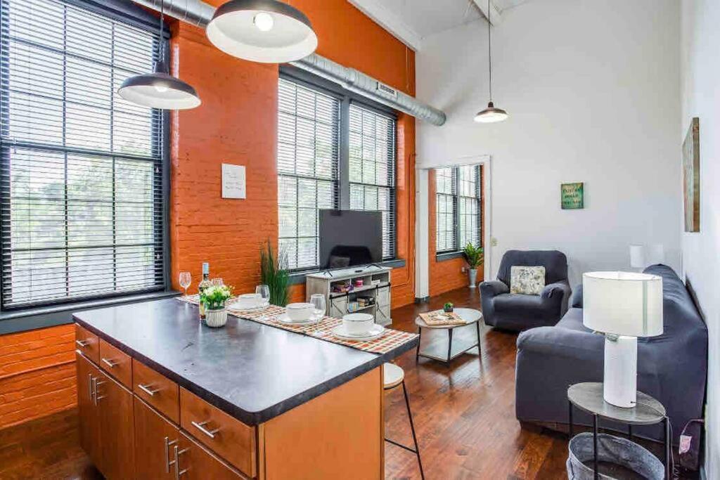 a living room with a couch and a table in a room at NY Style Centric Loft with King Bed by Park av. in Rochester