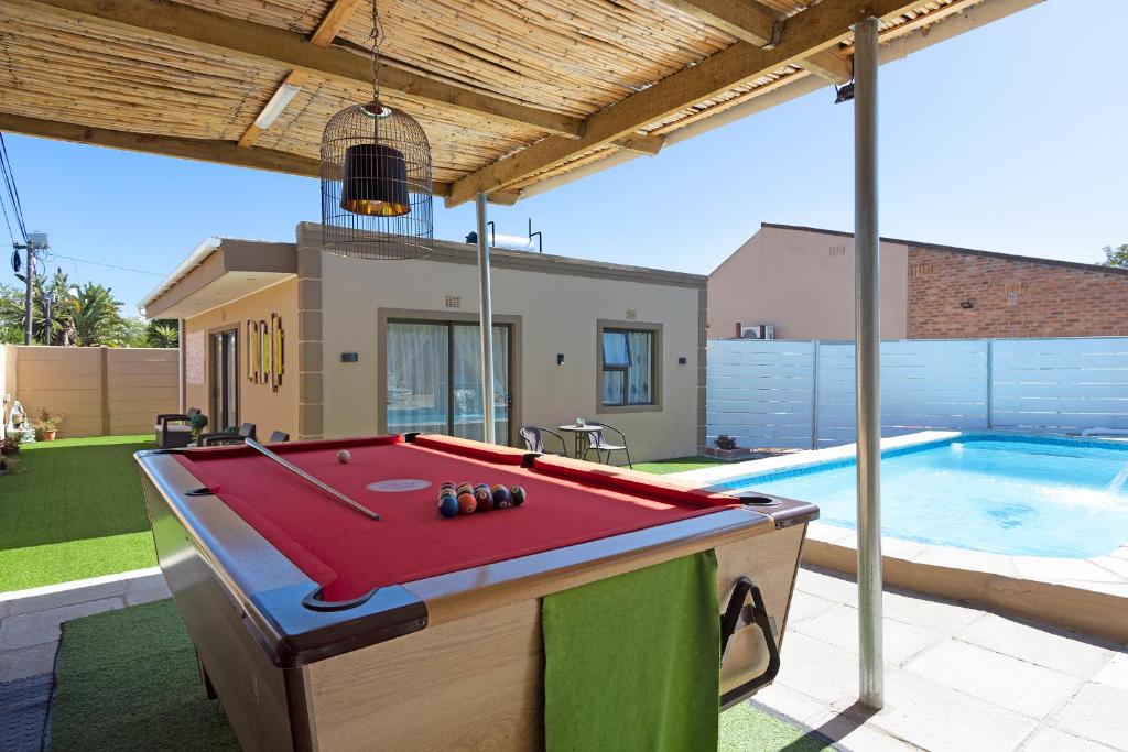 una mesa de billar en un patio junto a una piscina en Marigold - No Load Shedding en Brackenfell