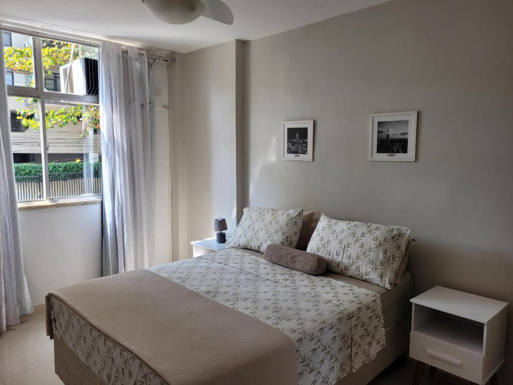 um quarto com uma cama e uma janela em Apartamento em Niterói - Boa Viagem em Niterói