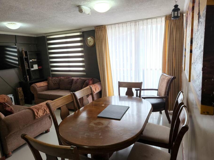 - un salon avec une table et des chaises en bois dans l'établissement Departamento en Dichato, 4 personas frente a la playa, à Dichato
