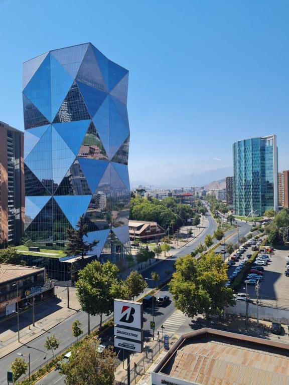 a view of a city with a building at Departamentos Pontoni Manquehue in Santiago