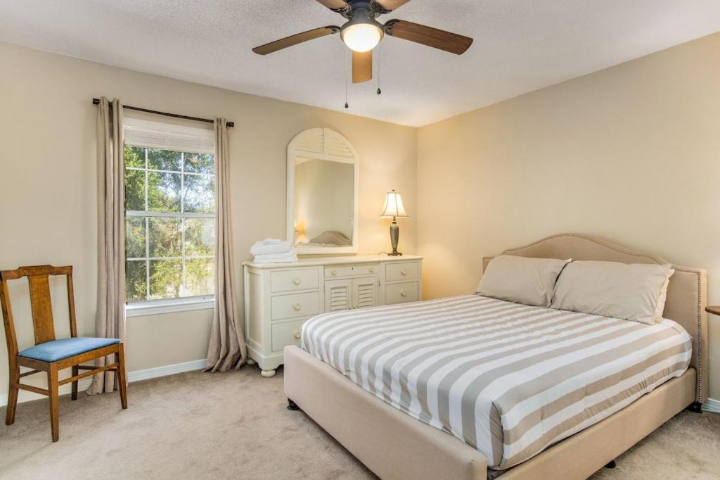 a bedroom with a bed and a ceiling fan at Bayside Manor near Airport & Beaches in Pensacola