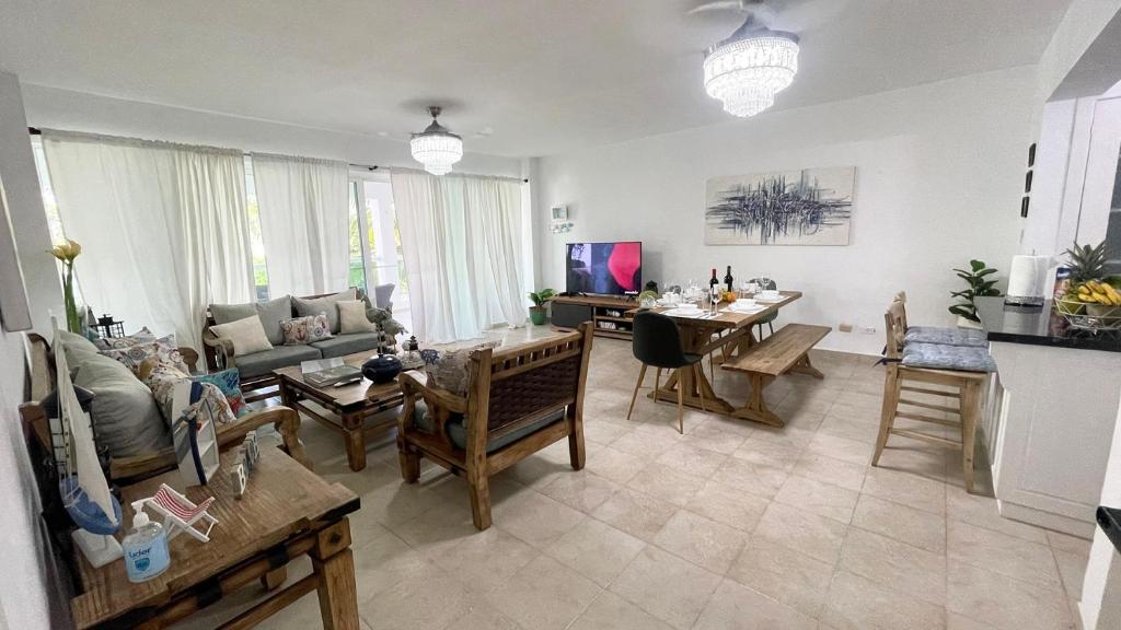 プンタ・カナにあるSunny Caribbean Apartment with Poolのソファとテーブルのあるリビングルーム