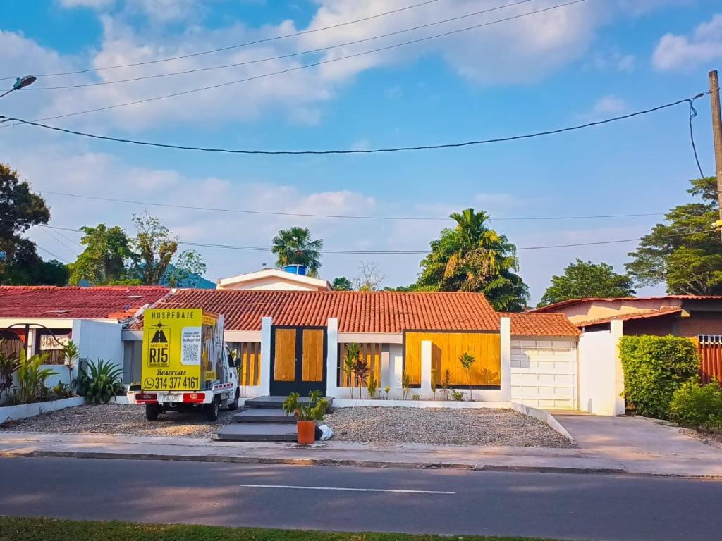 un camion jaune garé devant une maison dans l'établissement Casa hotel Aeroclubr15, à Villavicencio