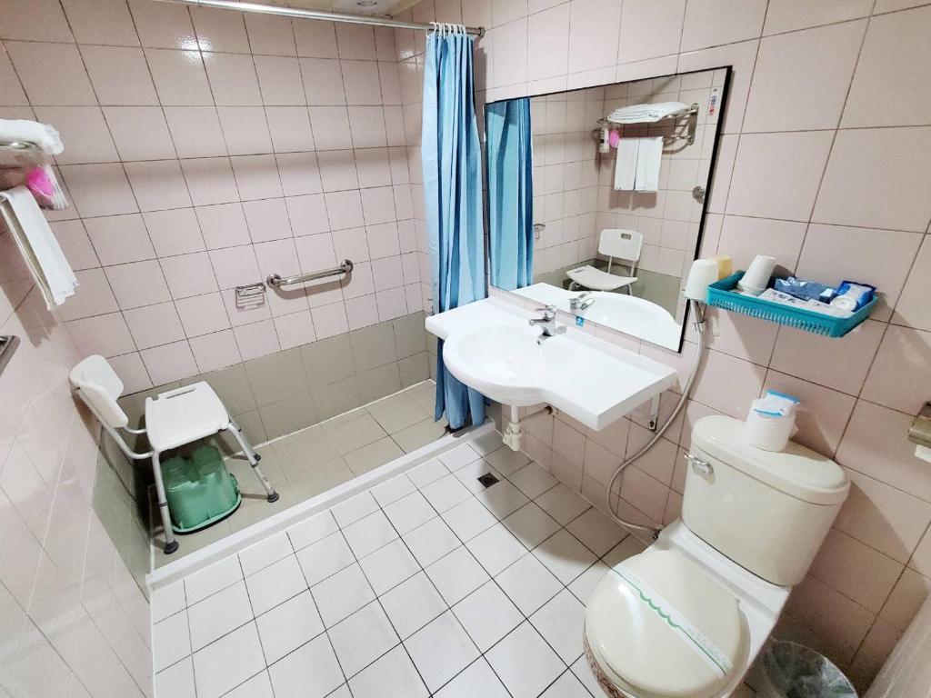 a bathroom with a toilet and a sink at Hua Ku Hotel in Tainan