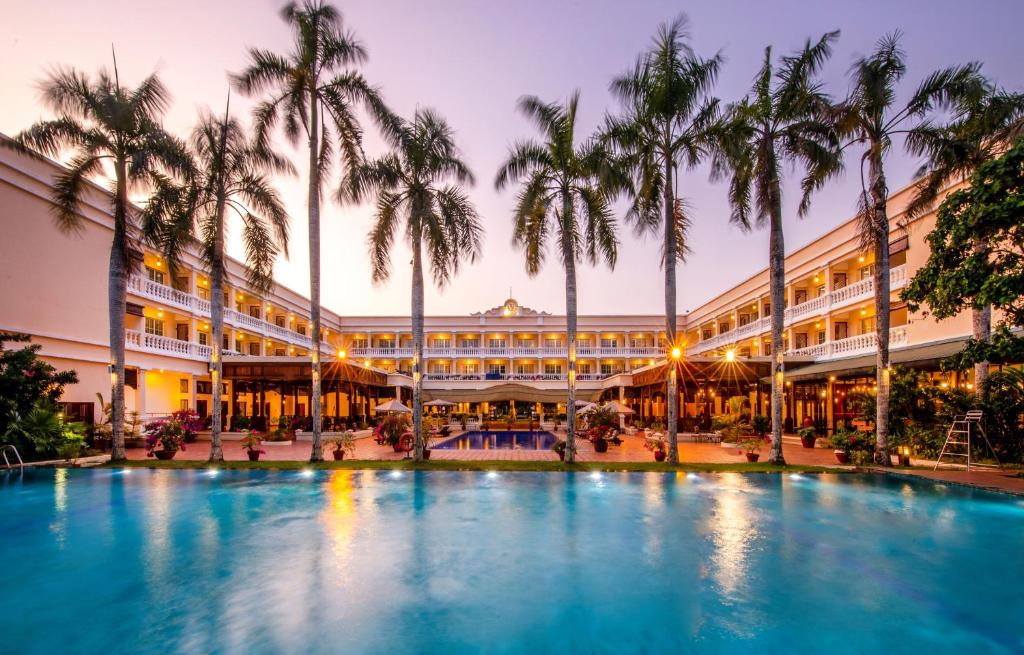 duży hotel z palmami przed nim w obiekcie Victoria Can Tho Resort w mieście Cần Thơ