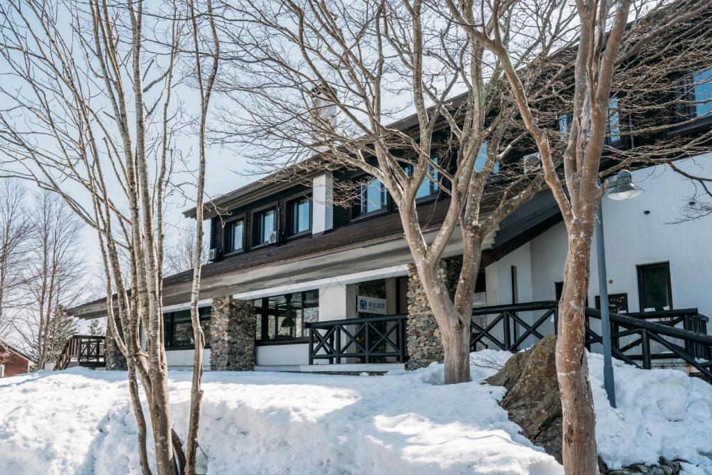 a house in the snow with trees at Apikogen Mori no Hotel in Hachimantai