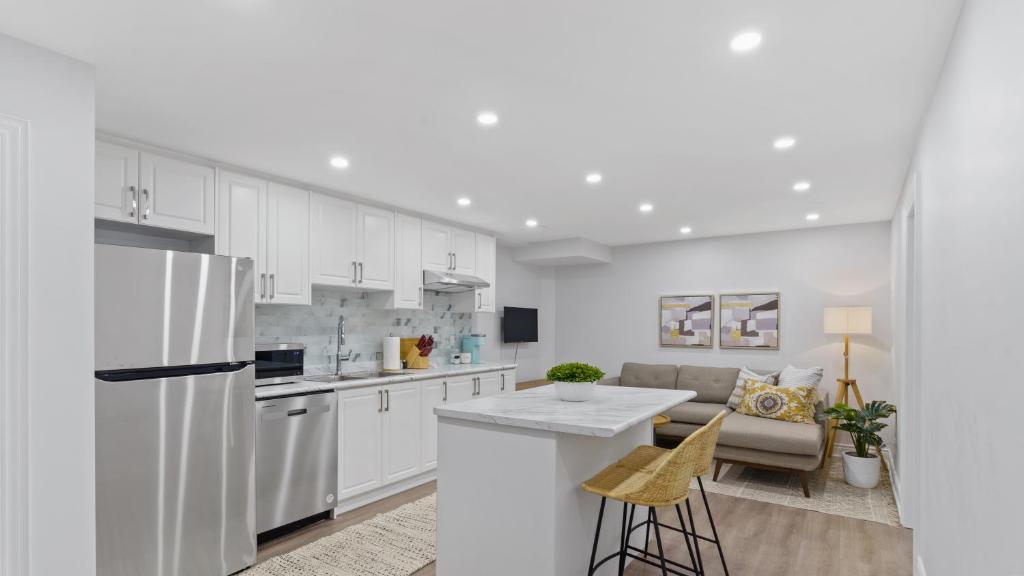 a kitchen with white cabinets and a white refrigerator at Family Friendly - Cozy - HOT TUB - Near UOIT in Oshawa