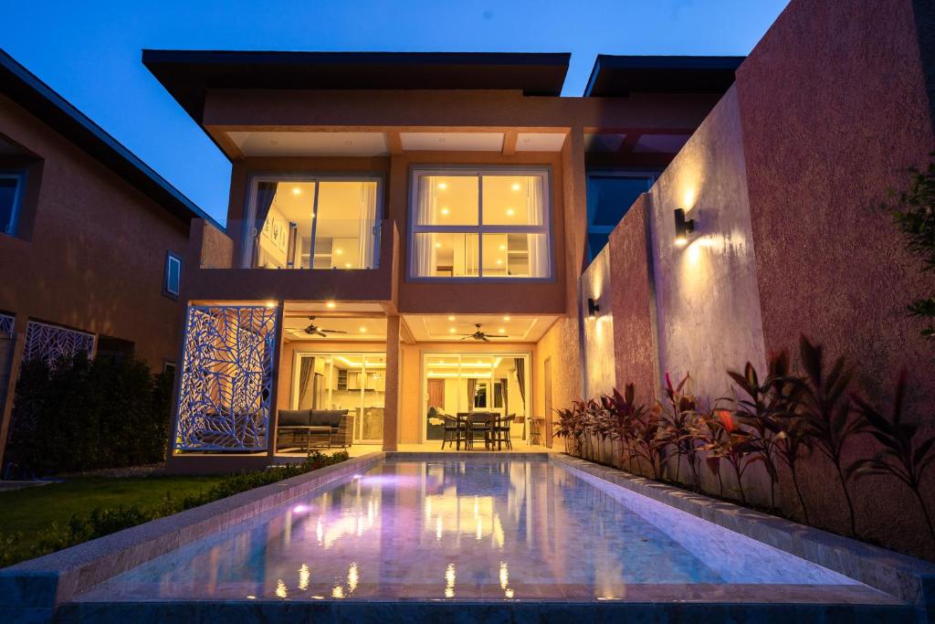 a house with a swimming pool in front of a house at Perla Pool Villa - Koh Chang in Ko Chang