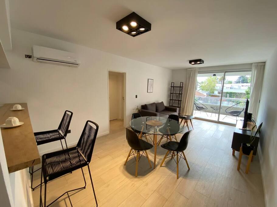 a living room with a glass table and chairs at Departamento céntrico a estrenar - Con piscina y parking incluido in Tigre