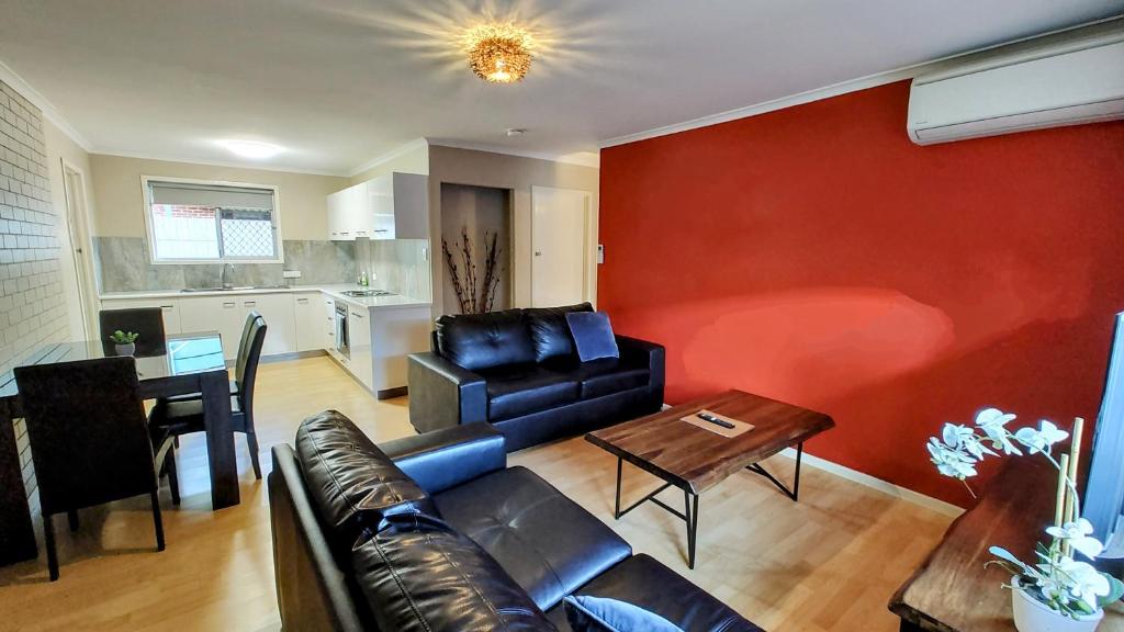 uma sala de estar com um sofá e uma mesa em 5 min walk to City Center em Toowoomba