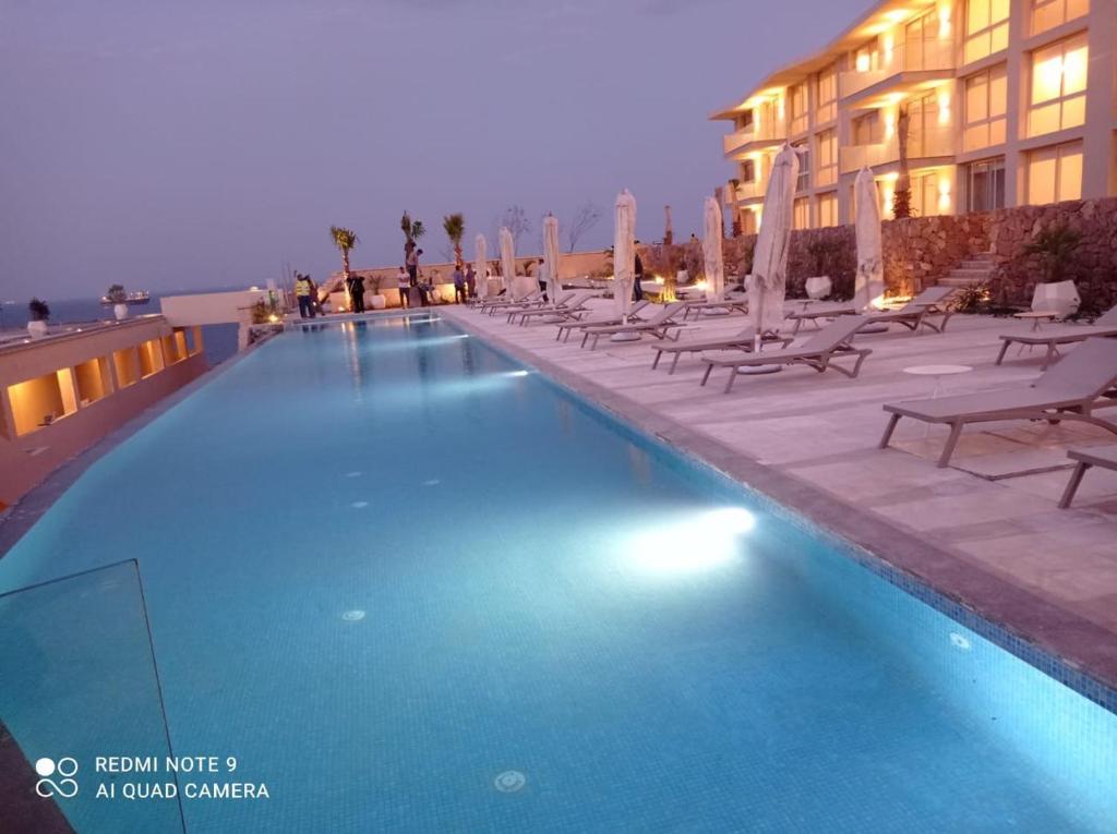 a large swimming pool with chairs and a building at Sea view il monte galala chalet in Ain Sokhna