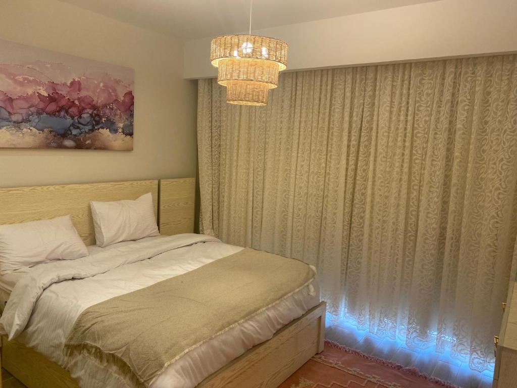 1 dormitorio con cama y lámpara de araña en Sea view il monte galala chalet, en Ain Sokhna