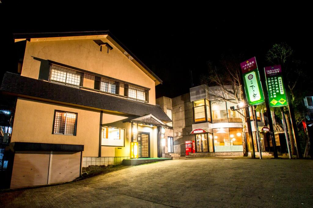 un edificio con un cartel delante de él por la noche en Oyado Hisaya, en Kami