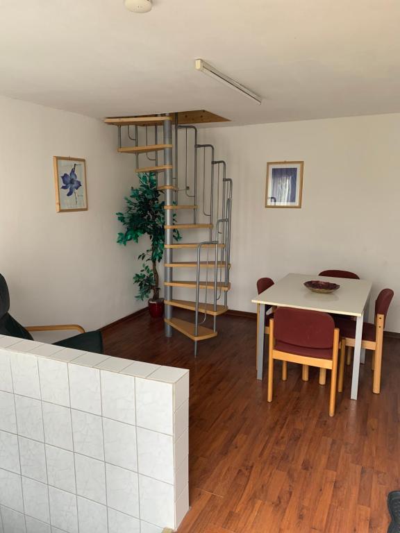 ein Wohnzimmer mit einem Tisch und einer Wendeltreppe in der Unterkunft Zentrale Wohnung (Essen Duisburg Düsseldorf) in Mülheim an der Ruhr