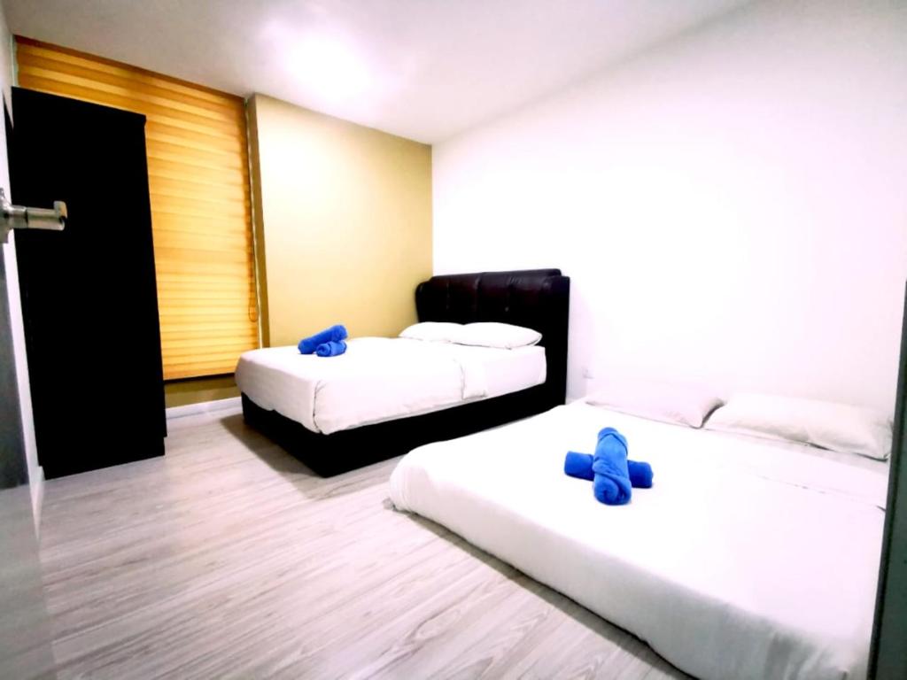 two beds in a hotel room with blue pillows at reSTARY - K-Box, Sutera Avenue Infinity Pool - Imago Opposite - KK City- 2BR,6Pax 来沙旅 K房主题公寓 - 无边际日落海景泳池 - Imago商场对面 - KK市中心 - 2房6人 in Kota Kinabalu