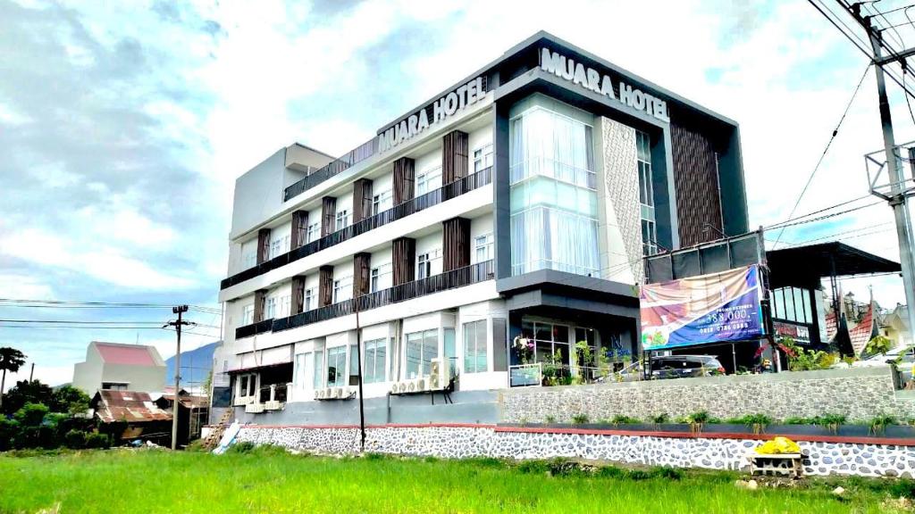 un gran edificio blanco con un cartel. en Muara Hotel Bukittinggi en Padangluar