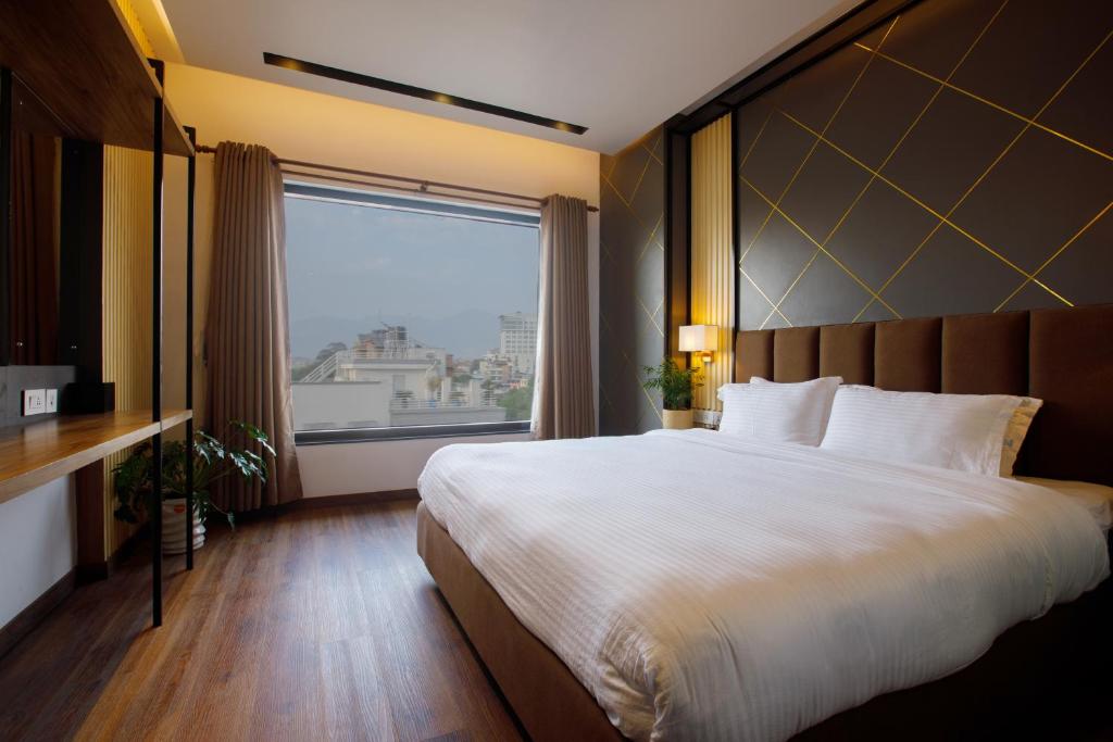 Sangam City Hotel Pure Veg في كاتماندو: غرفة نوم بسرير كبير ونافذة كبيرة